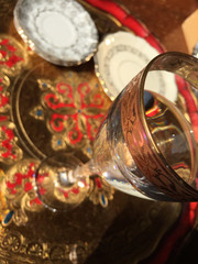 Detail of glass, on the background: decorated saucers and tray