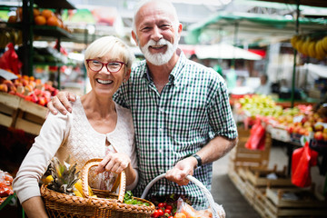 Only the best fruits and vegetables. Beautiful mature couple buying fresh food on market