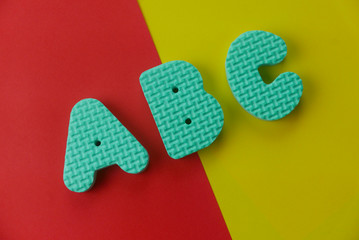 Top view of alphabet ABC on two color background which are red and yellow.