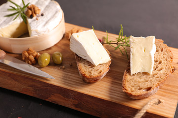 bread slice with camembert on wooden board