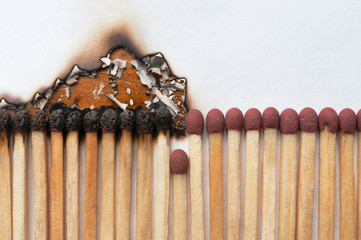 Covid-19 social distance concept: A row of matches, half of which burnt and half new, separated by...