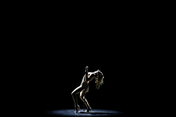 Silhouette of Beautiful good shaped blond woman singing on the stage with microphone