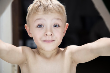 Closeup of a beautiful young blonde boy with a cheerful expression.