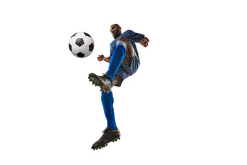 Fototapeta na wymiar Football or soccer player on white background with grass. Young male sportive model training, practicing. Attacking, catching. Concept of sport, competition, winning, motion, overcoming. Wide angle.