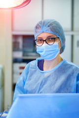 Closeup portrait of a young female doctor wearing a mask. Fighting virus. Pneumonia diagnosting. COVID-19 and coronavirus identification. Pandemic. - obrazy, fototapety, plakaty
