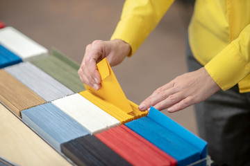 Female hands taking out yellow envelope from the selection