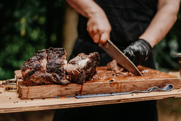 man is cutting meat on wooden table