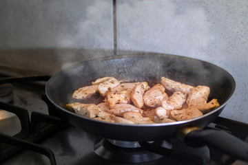 Chicken being cooked on the stove with steam blowing up in the air