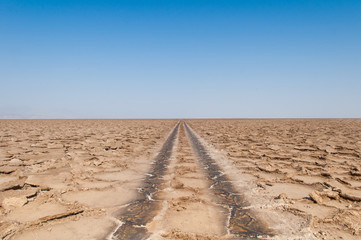 Afar region, Danakil Depression, Northern Ethiopia, Salt Desert, Road to Nowhere, Cracks in Road, Endless View, Noon, Clear Blue Sky