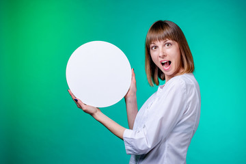 confectioner young girl in white culinary tunic hold  white circle in hands and looks at camera on cyan background. confectionery cooking concept