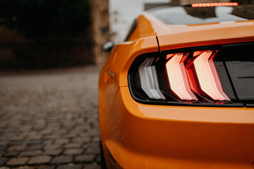 rear lights of orange car on the street from behind with copy space - Powered by Adobe
