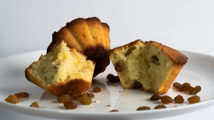 Sweet homemade cupcake with raisins on a white plate.