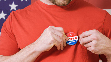 Man putting on I Voted Today button for Presidential election 2020 in America.