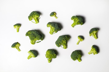 Clean eating concept. Bunch of ripe juicy freshly picked organic broccoli heads, green curds isolated on white background. Healthy diet for spring summer detox. Vegan raw food. Close up.