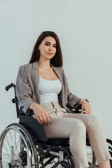 Fototapeta na wymiar Disabled woman looking at camera on wheelchair isolated on white