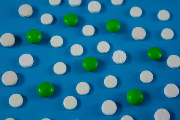 many white and green pills on a blue background