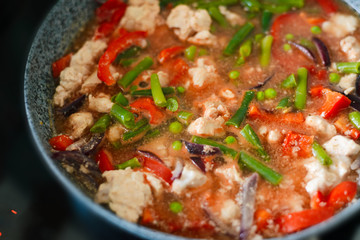 Thai Panang chicken Curry in a frying pan on the stove. Cooking. Boiling. Phanaeng Curry is a Thai dish with chicken, red curry sauce and vegetables. Thai cuisine. Thai food.