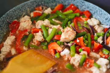 Thai Panang chicken Curry in a frying pan on the stove. Cooking. Boiling. Phanaeng Curry is a Thai dish with chicken, red curry sauce and vegetables. Thai cuisine. Thai food.