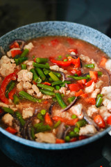 Thai Panang chicken Curry in a frying pan on the stove. Cooking. Boiling. Phanaeng Curry is a Thai dish with chicken, red curry sauce and vegetables. Thai cuisine. Thai food.
