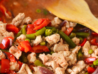 Thai Panang chicken Curry in a frying pan on the stove. Cooking. Boiling. Phanaeng Curry is a Thai dish with chicken, red curry sauce and vegetables. Thai cuisine. Thai food.