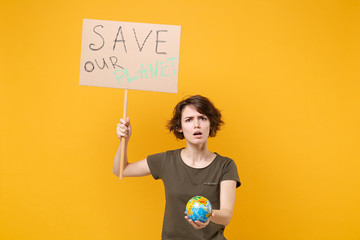 Shocked young protesting woman hold protest sign broadsheet placard on stick Earth world globe isolated on yellow background. Stop nature garbage ecology environment protection concept. Save planet.