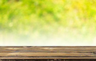 Fototapeta premium Empty wooden table and blurred green nature background. Natural template with beauty bokeh and warm sunlight. Concept banner for products display
