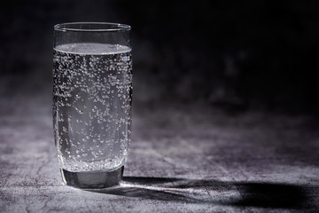 Glass of sparkling water on the grey background