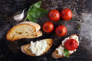 toasted bread with cheese, grilled tomatoes, basil and garlic. crostini.
