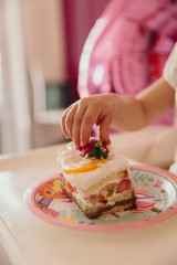 baby's hand takes a birthday cake