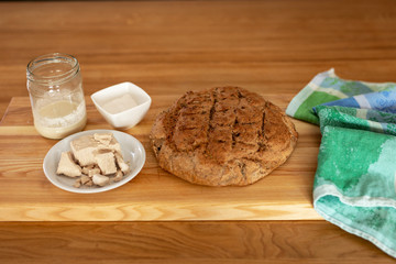 yeast for baking. Dry yeast, pressed yeast and homemade yeast (sourdough) on an oak table next to freshly baked bread.