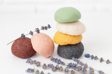 natural sponge konjac for face and body care, cleansing sponge on a white background with lavender flowers