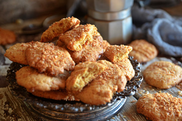 Cookies with coconut flakes on a rustic dish on a wooden background