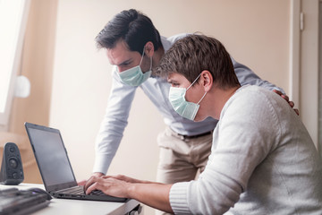 Obraz premium Two businessmen with protective masks working from quarantine