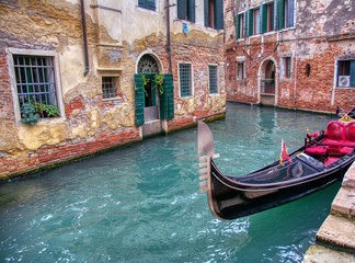 Fototapeta na wymiar Gondola sailing through a canal in Venice.