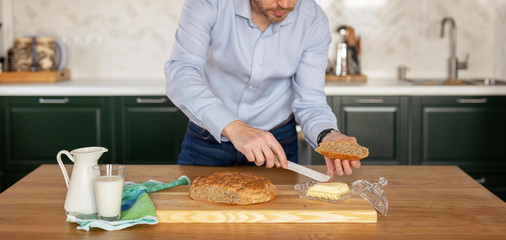 A man in a official shirt cuts freshly baked homemade bread