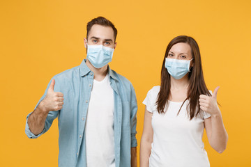 Two people in sterile face masks white t-shirts isolated on yellow background studio. Epidemic...