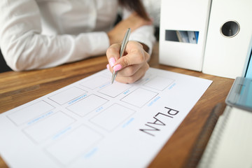 Woman draws up paper financial payment boards. Account grouping and cash flow analysis. Multilevel structure categories and projects. Consolidate finances balance for reporting period