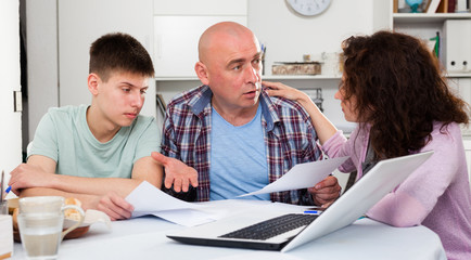 Chagrined family analyzing finances