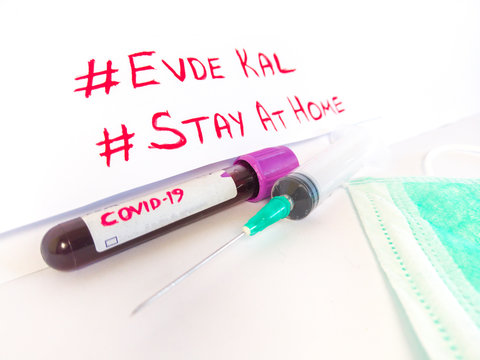 "stay at home, evde kal"writing on it,in English and Turkish. Test tube with blood sample for COVID-19 test