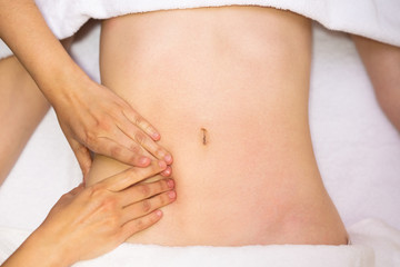 Woman receiving a belly massage at spa salon - obrazy, fototapety, plakaty