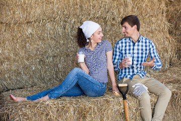 Naklejka na ściany i meble man and woman in hay with milk