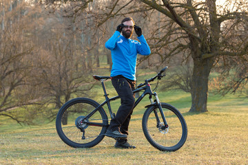 Fototapeta premium Cyclist in pants and fleece jacket on a modern carbon hardtail bike with an air suspension fork. The guy on the top of the hill rides a bike.