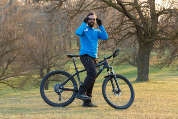 Cyclist in pants and fleece jacket on a modern carbon hardtail bike with an air suspension fork. The guy on the top of the hill rides a bike.