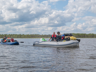 Landscape of harsh Karelian nature with boats in lake. Active extreme ecotourism in Karelia. Water rafting in North lakes and rivers