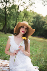 Young attractive girl holds a summer wildflower.