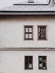 Old white building with windows and roof. Front view. Architecture, minimal background.