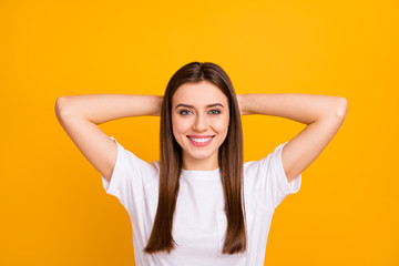 Closeup photo of pretty calm lady good mood napping thinking arms behind head delighted toothy smile wear casual white t-shirt isolated vivid yellow color background