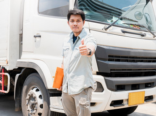 Portrait of Asian truck driver looking with giving thumb-up and a truck 