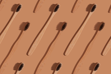 A row of wooden toothbrushes on a brown background.