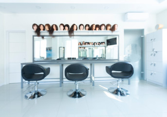 Blurry barber shop interior with wigs on mannequins